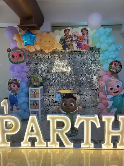 For Parth's first birthday, we combined a Cocomelon theme with a silver sequin wall. The large marquee letters and character cutouts made it a perfect photo spot.
