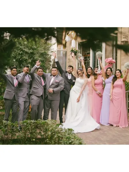The bride and groom celebrating with their entire wedding party. This photo is full of energy and joy, capturing the collective happiness of the day.