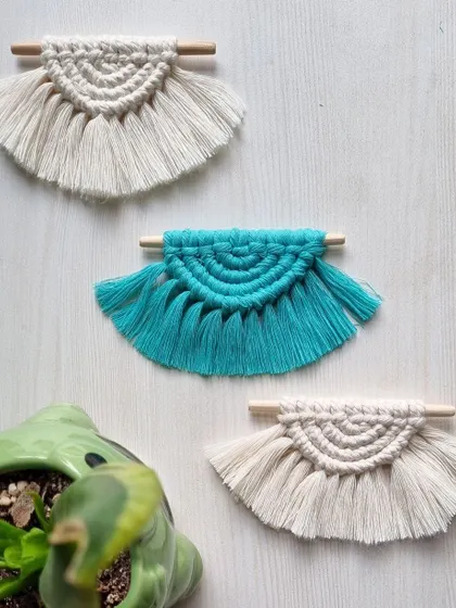 These small, fan-shaped macrame hangings are made from scrap cords, ensuring nothing goes to waste. They are great as ornaments or small decorative accents.
