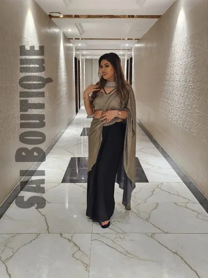 A full-length shot of the bride's mami in her stunning black and gold draped saree. A timeless and glamorous choice.