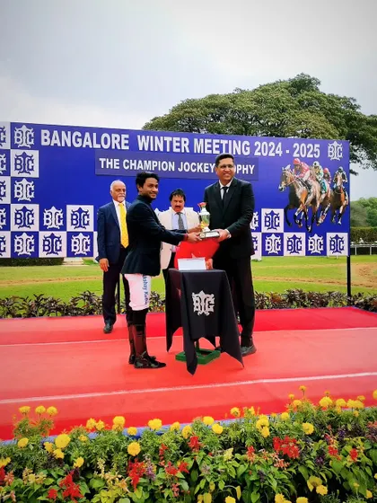 Jockey Akshay Kumar presents The Champion Jockey Trophy to the winner, Darshan R.N.