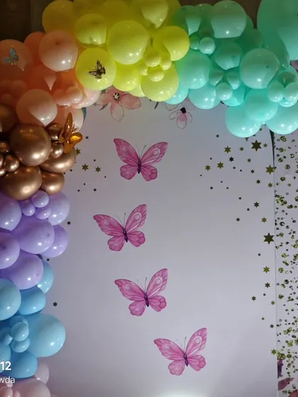The full rainbow-colored balloon arch with gold and butterfly accent's.