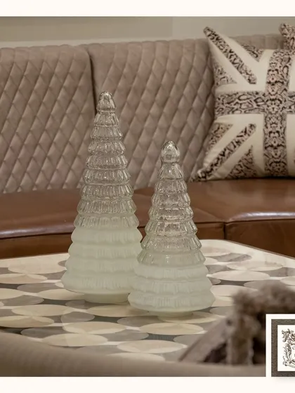 These elegant glass Christmas tree centerpieces are perfect for adding a touch of festive sparkle. Their clean, modern design complements the classic leather sofa and Union Jack cushion.