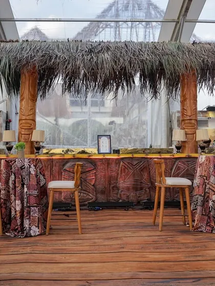 The main bar, designed to look like a tropical beach shack with a thatched roof and a facade of printed fabric with tribal patterns.