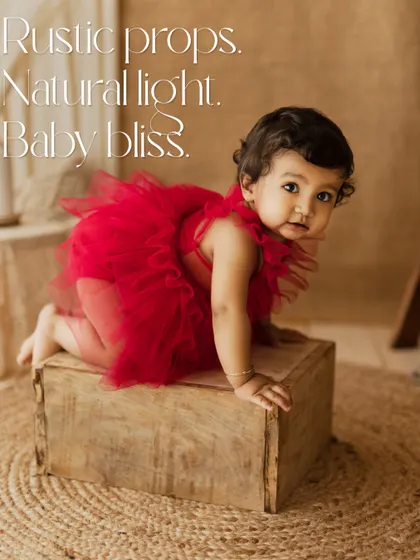 Rustic props, natural light, baby bliss. This little one in a vibrant red tutu is exploring a wooden box, a beautiful contrast of color and texture.