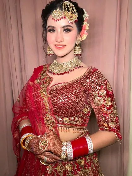 A happy bride is the most beautiful bride. Her smile truly completes this classic red and gold bridal look.