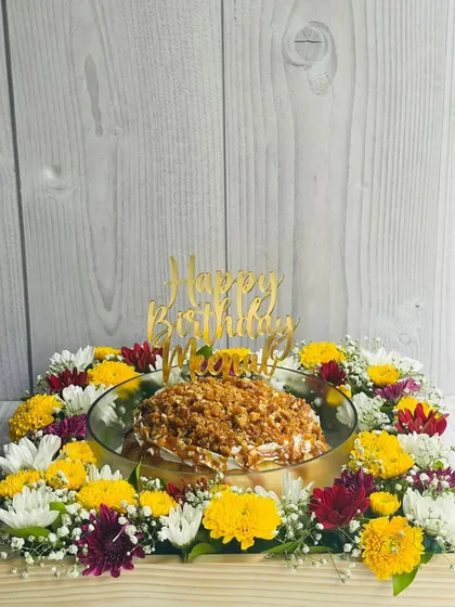 A wider view of the personalized Butterscotch Caramel Tres Leches hamper, showing how the cake and flowers come together to create a complete and impressive birthday gift.