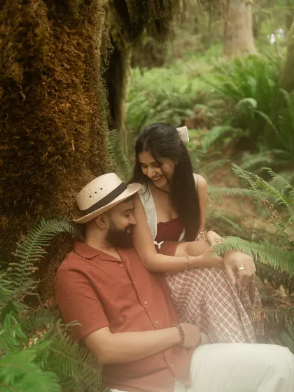 A sweet, candid moment of laughter shared between the ferns and moss-covered trees of the rainforest. These are the real, unscripted moments we love to capture.