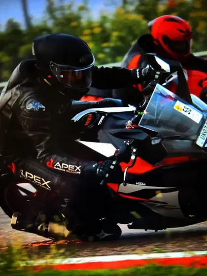 A rider on a KTM scrapes their knee puck, sending sparks flying. This is the kind of aggressive, committed riding that our safe track environment encourages.