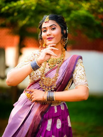 This pose highlights the rich temple jewellery that pairs so well with a traditional langa voni. The heavily embroidered blouse and the silk skirt create a look that is both grand and graceful.