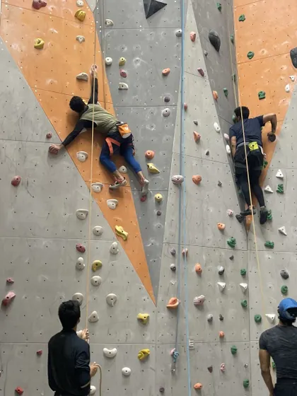 Two climbers ascend parallel routes, showcasing different styles and techniques.