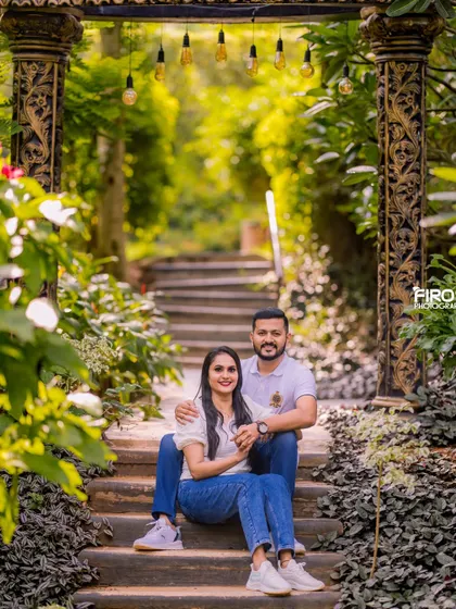 A relaxed and happy portrait of a couple sitting on garden steps. Their casual jeans and white shirts create a clean, classic look that is always in style.