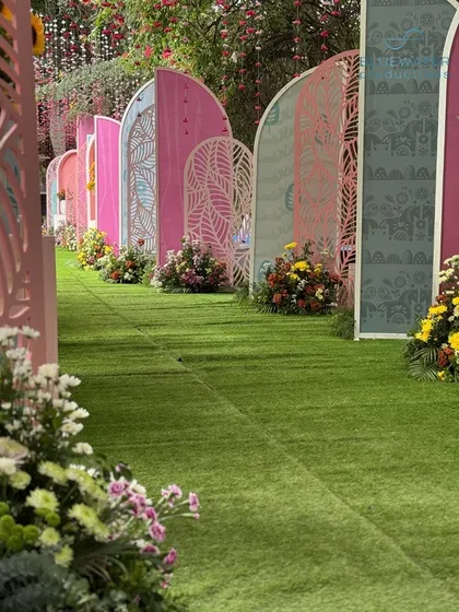 The arched pathway creates a whimsical and immersive experience for guests as they make their way into the main event area.