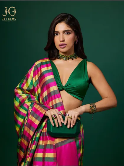 A powerful pose showcasing a collection of our statement gemstone rings and a matching emerald choker against a colourful, modern sari.