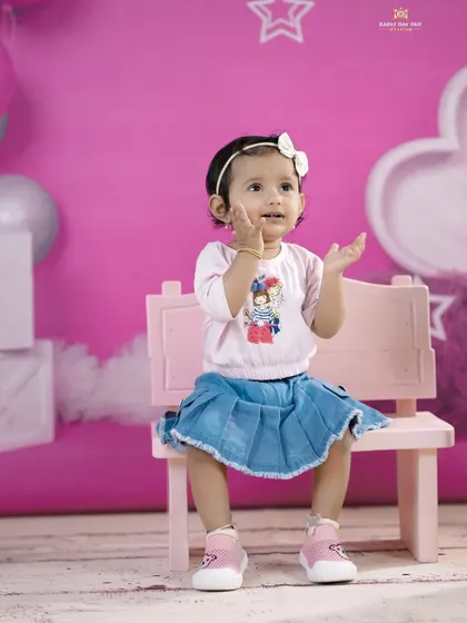 A cute and expressive pose from a little girl on a pink bench. We love capturing their playful hand gestures and animated faces.
