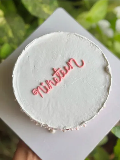 "Nineteen." A simple and chic minimalist cake with a textured top and a delicate pearl border, perfect for an elegant birthday.