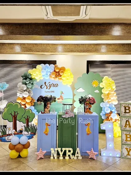 Nyra's first birthday was a "quacking" good time with this delightful duck theme. The setup includes large duck cutouts, a pond-like backdrop, and a light-up number "1" to celebrate her special day.