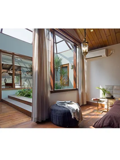 The master bedroom in the 'Aangan' house, seen from a wider angle. The room is designed as a personal retreat, with its own private view of an internal courtyard, blending privacy with a deep connection to nature.
