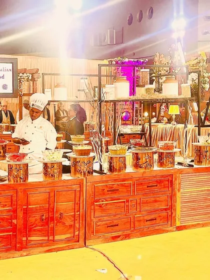 A live Italian salad station with a rustic wooden setup. This inviting counter design, complete with warm lighting and a clear menu, makes the food experience interactive and visually appealing.