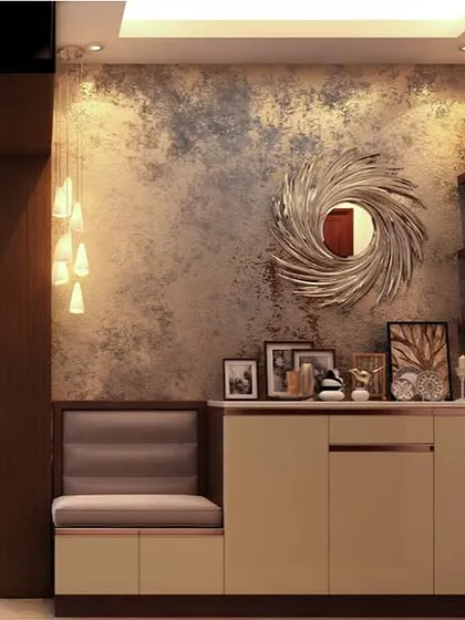 This elegant foyer features a console with a built-in padded seat. The textured wall, decorative mirror, and pendant lighting create a glamorous first impression.