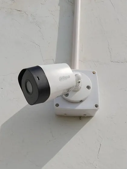 Another example of a clean outdoor installation of a Dahua bullet camera against a white wall.