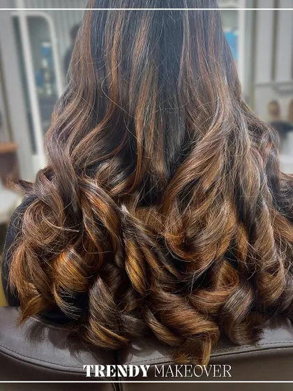 A trendy makeover featuring rich caramel and copper tones. The bouncy curls add volume and show off the beautiful dimension of the highlights.