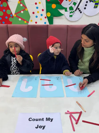 Christmas-themed math makes learning festive. Here, children are using red sticks to practice counting with our "Count My Joy" activity, blending holiday fun with essential number recognition skills.