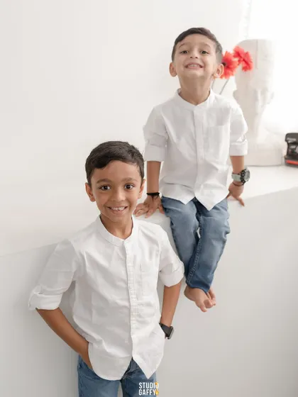 A portrait of two brothers, their smiles and coordinated outfits creating a classic and handsome shot.