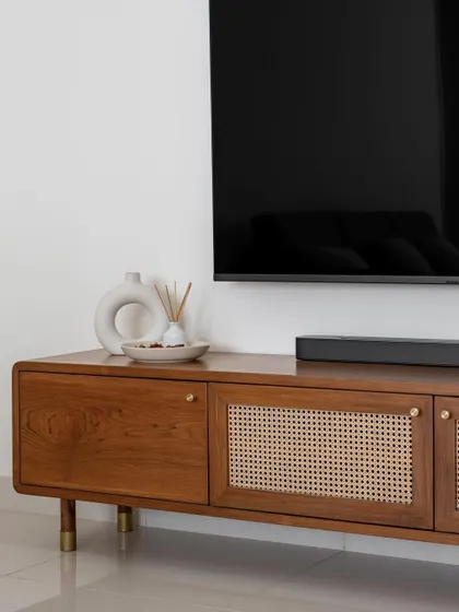 The 'Marshall' TV unit combines solid wood and rattan shutters, all integrated with our signature curved edges, brass knobs, and tapered legs.