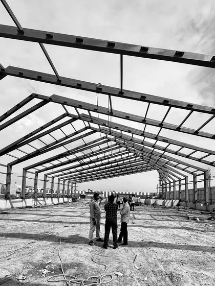 "Roof Likes To Swing": A series of black and white photos tracking the progress of a large-scale steel roof structure for an experience center in Chennai.