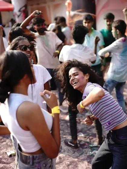 The carefree spirit of a Holi festival, captured in the smiles and dance moves of the partygoers.