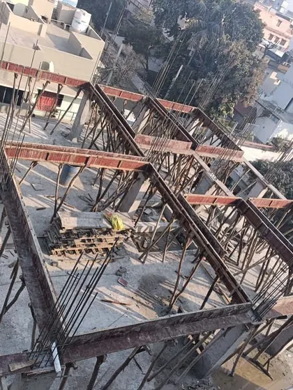 An overhead view of shuttering, the temporary formwork used to mold concrete for the next floor's beams and slab. This grid-like structure is fundamental to multi-story construction.