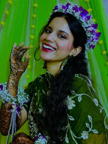 A happy bride with a beautiful floral crown, her smile as bright as her henna.