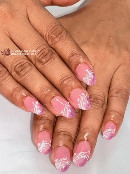 A soft and pretty design with a pink base, a touch of purple glitter at the tips, and delicate white swirls. This is a lovely, understated look for shorter almond nails.