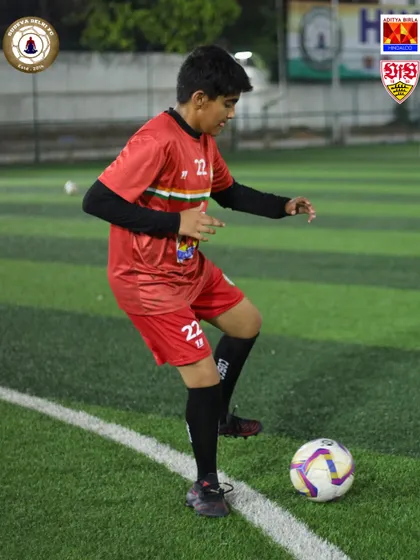 Focus and control. A player prepares to make his next move, keeping the ball close to his feet. This fundamental skill is the key to effective dribbling.