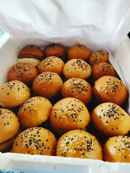 Freshly baked veg sliders ready for a birthday party. Topped with sesame seeds, these mini burgers are a quick, easy, and delicious vegetarian appetizer that kids and adults love.