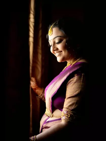 A classic bridal portrait using dramatic side lighting. The play of light and shadow beautifully sculpts her features and highlights her happy, serene expression.