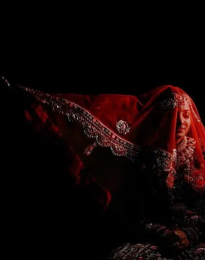 My award-winning photo, capturing a bride under her red veil in a dramatic play of light and shadow. This image represents my commitment to creating powerful, artistic photography.