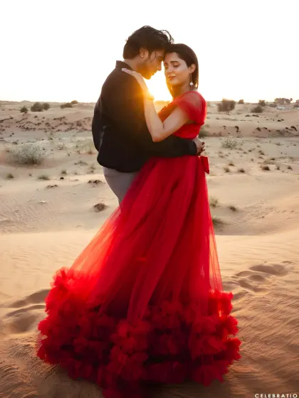 An intimate moment during a desert photoshoot. The ruffled red gown adds texture and romance to this beautiful sunset portrait.
