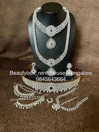 A complete Victorian-style bridal set with a white diamond finish. This rental includes a choker, long necklace, vaddanam, and hand accessories.
