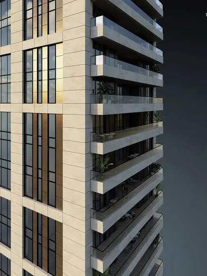 A detailed view of the Worli tower's facade, showing the interplay of glazed cladding and stone. The design adheres to our principles of simple lines, creating a sublime rhythm and timeless sophistication.