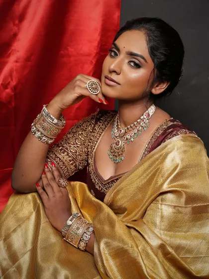A seated portrait showing the full elegance of the look. The makeup enhances her features, creating a look that is both regal and authentic.