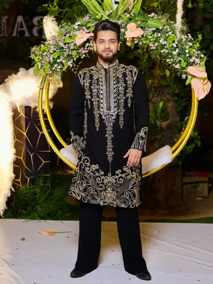 A full-length portrait showcasing our black kurta with heavy gold embroidery. This is a statement piece, designed for golden nights and grand celebrations like a wedding reception.