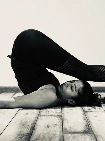 Halasana, or Plow Pose, is a deep forward-bending inversion that stretches the entire spine and shoulders. This pose is part of our 'Slow and Strong' practice, designed to build fluidity and strength.
