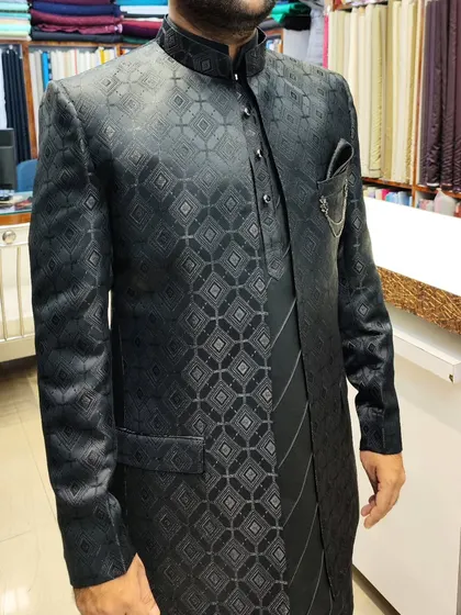 A sleek, black-on-black open shrug and jacket set. The geometric pattern on the jacquard fabric adds a subtle texture, perfect for an evening event.