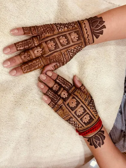 A sophisticated back-hand design combining Madhubani-style block patterns with delicate lotus motifs on the wrists. It's a great example of mixing traditional and modern elements.