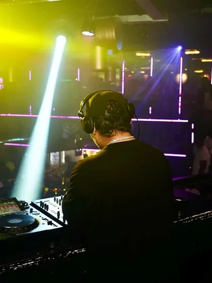 Here I am, your Party Ninja, in the zone with a spotlight on the decks. The focus is always on the music and the crowd's energy.