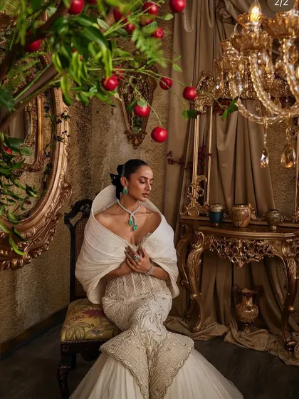 The ivory hooded gown, a piece of couture that speaks without shouting, captured in a moment of quiet contemplation.
