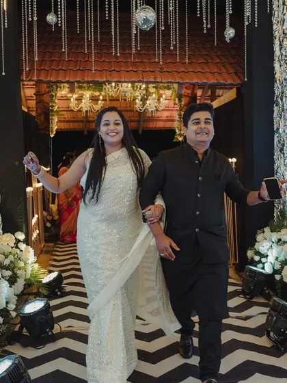 A glamorous guest entrance for a sangeet, featuring shimmering silver walls, a chevron floor, and dramatic uplighting.