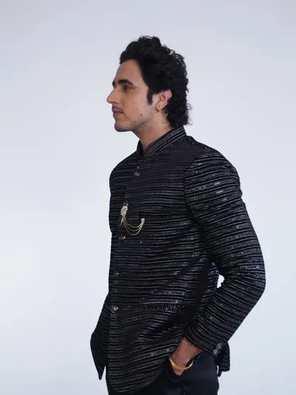 A side view of the black sequined bandhgala jacket, showing off its sleek silhouette and the subtle sparkle of the fabric.